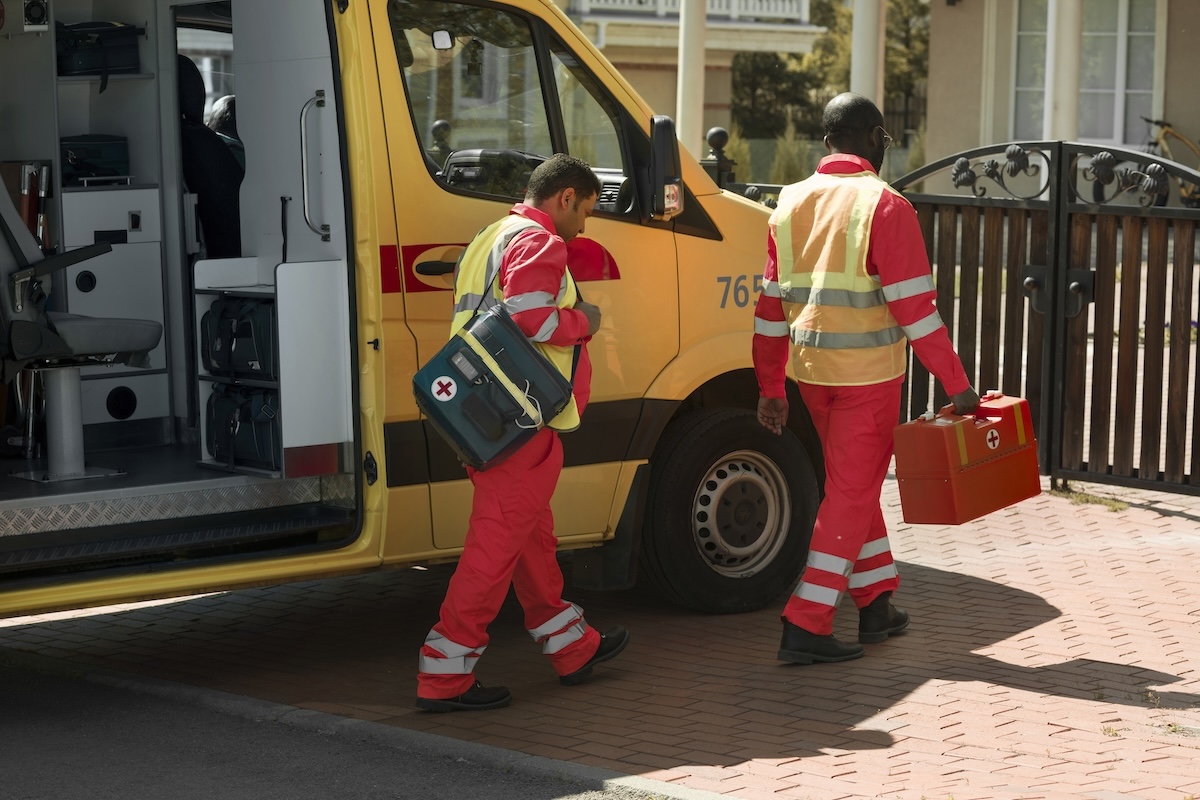 socorristas saindo de uma ambulância em um dia de sol