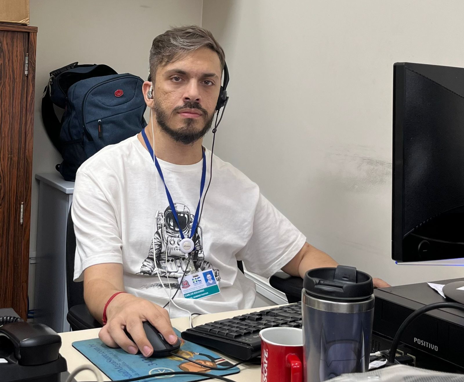 Homem sentado em frente a um computador