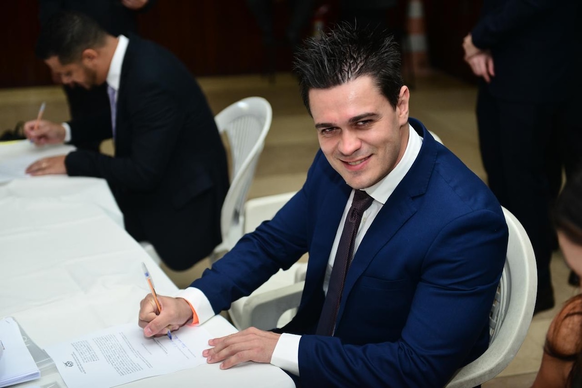 Felipe Costa assinando um papel